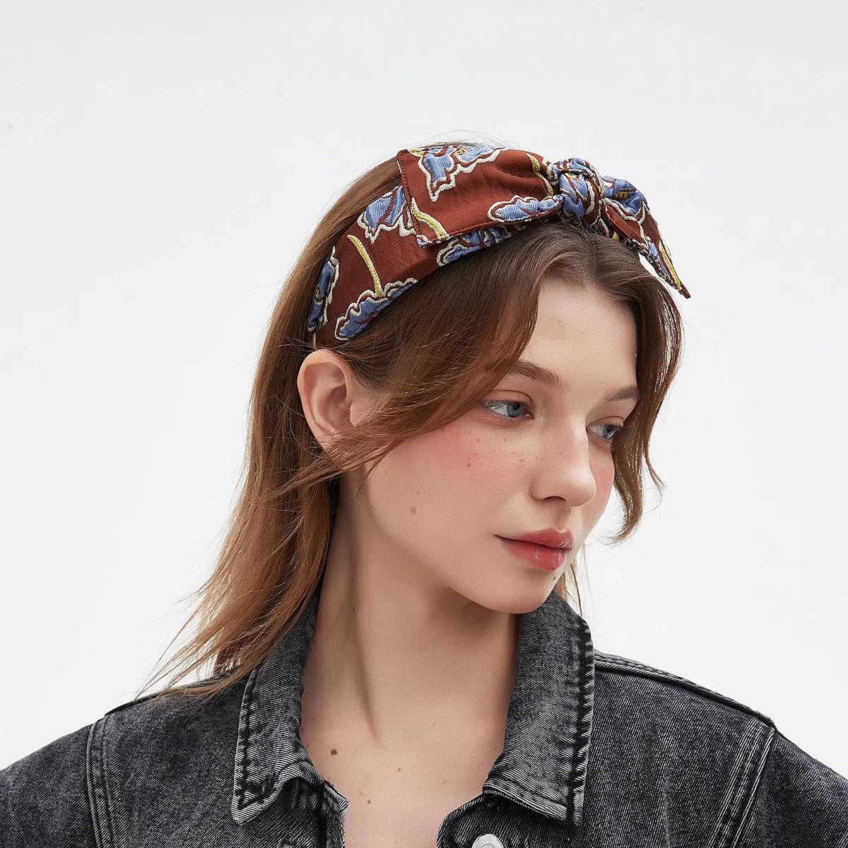 Women's bow headband in rust with blue and yellow floral print cotton fabric