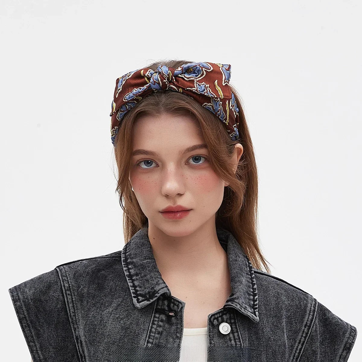 Brown printed bow headband with blue and yellow floral pattern on woman