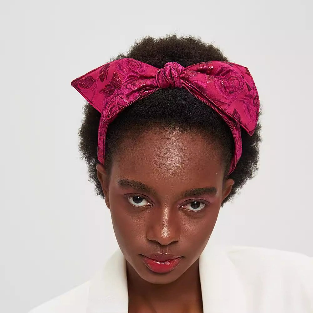 Magenta printed bow headband with textured floral pattern, wrapped knot style