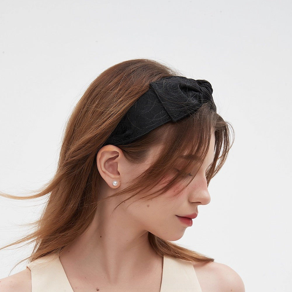 Black fabric bow headband with subtle floral pattern, women's embellished headband