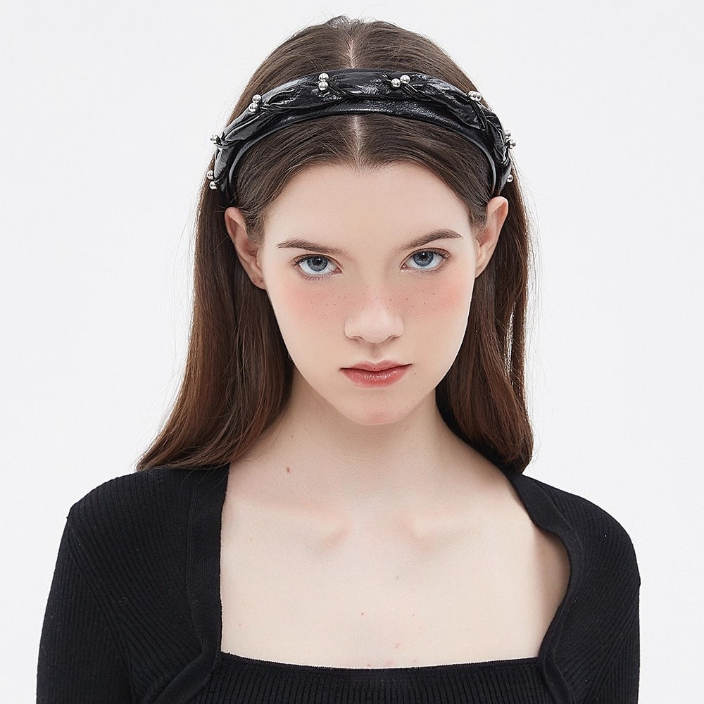 Black embellished women's headband with twisted design and silver bead details