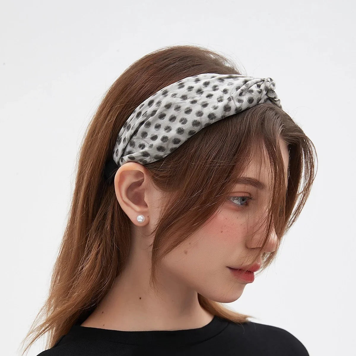 Gray polka dot printed fabric bow headband on woman with brown hair