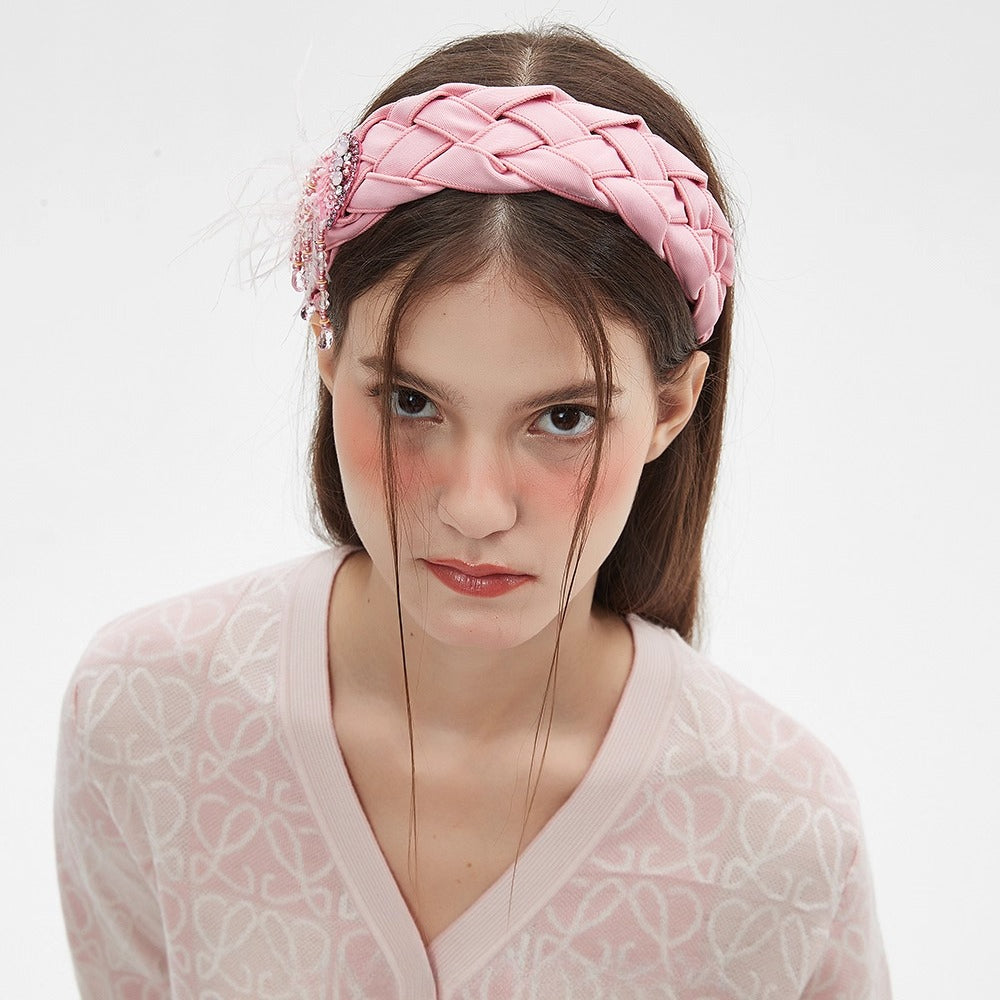 Pink braided fabric headband with embellished bead and feather detail, women's bow style