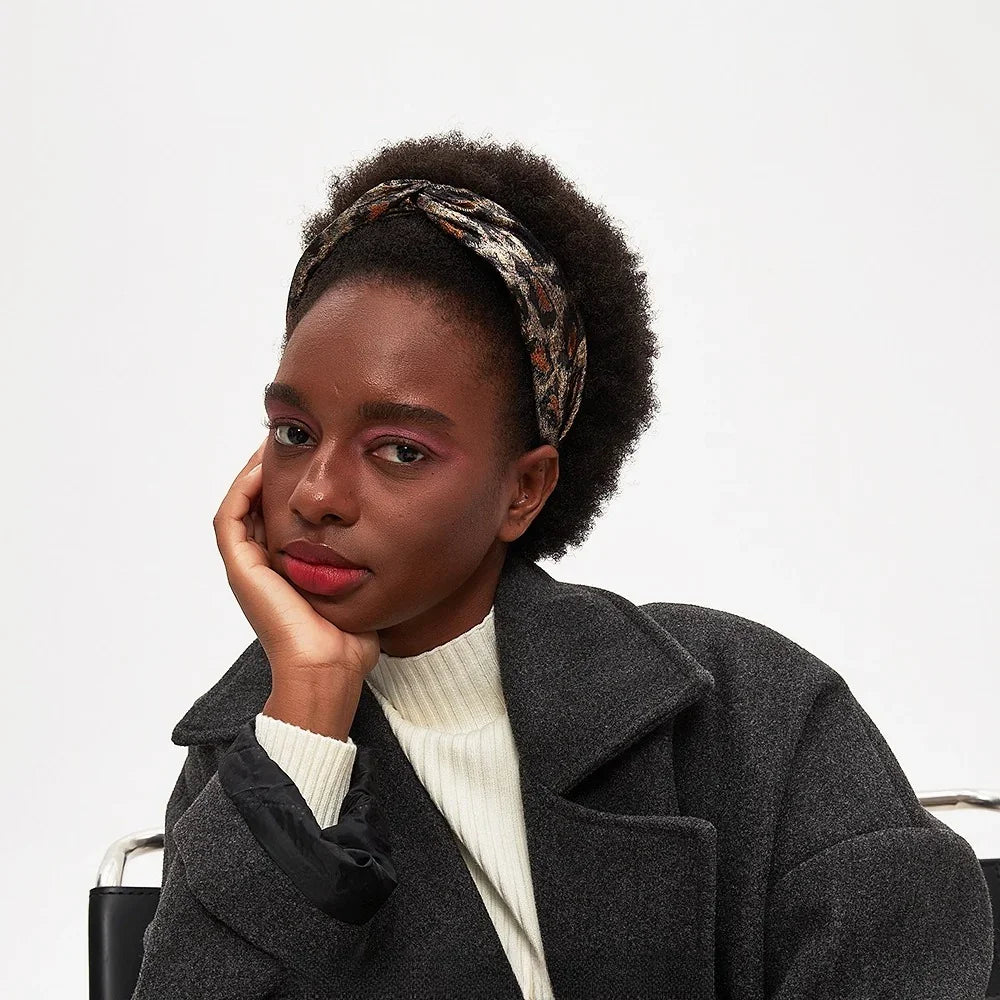 Women's leopard print bow headband in brown and black with metallic accents, stylish accessory