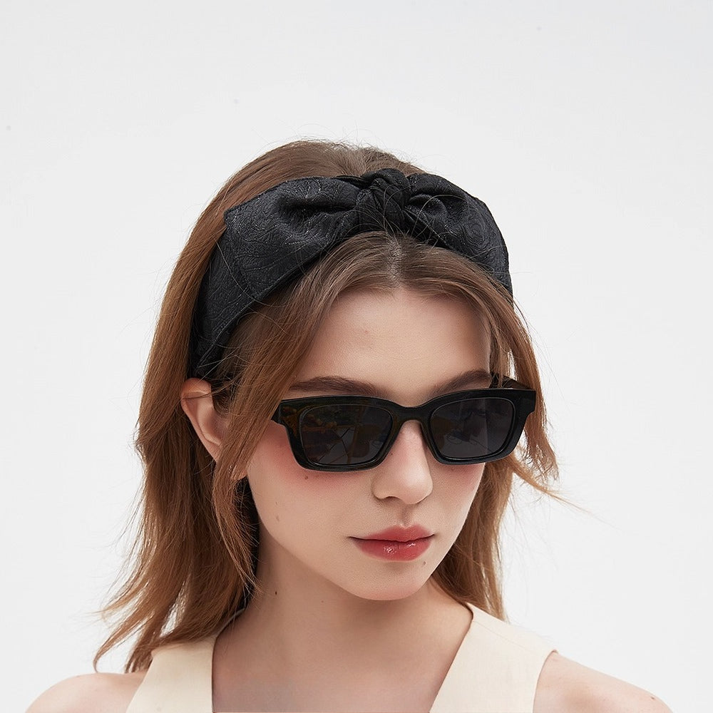 Black bow women's headband with subtle floral jacquard pattern, fabric material, embellished style