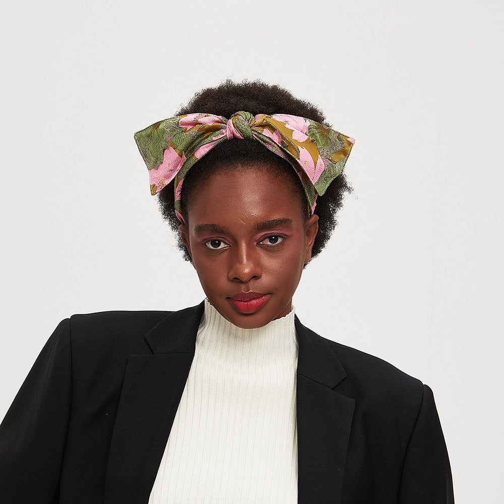 Floral printed bow headband with pink and green leaves on a woman