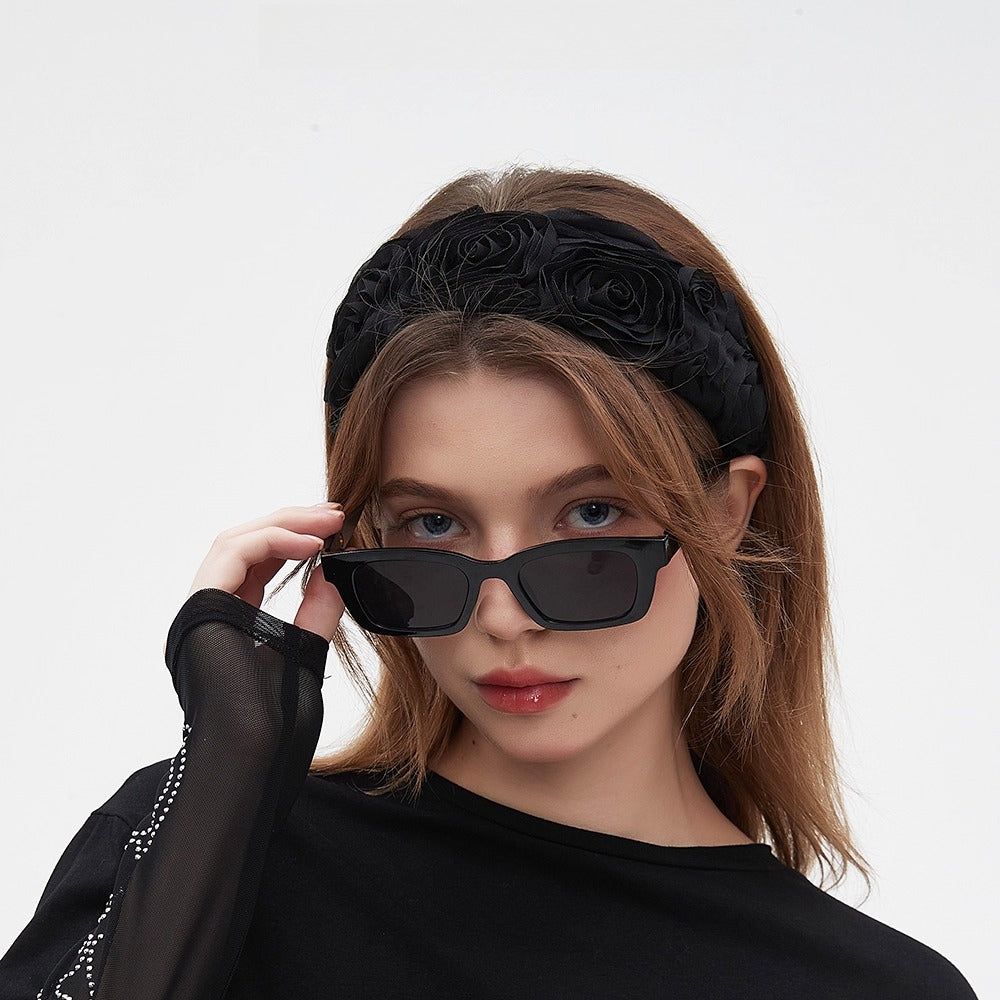 Black embellished women's headband with 3D floral design in fabric material
