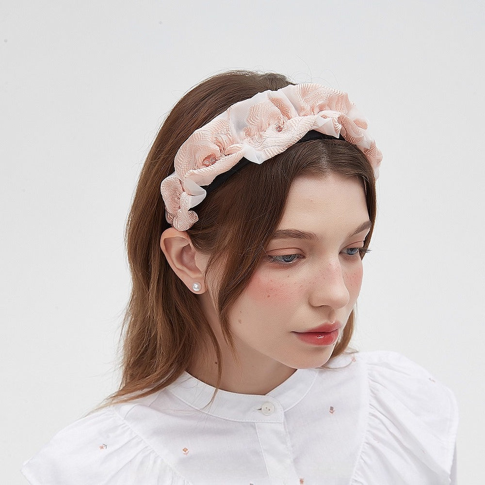 Women's blush pink embellished headband with fabric floral ruffles, soft textured material