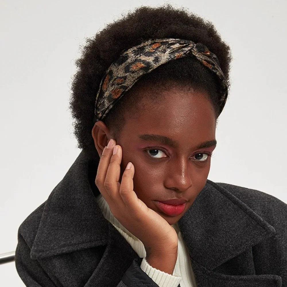 Printed leopard pattern women's bow headband in neutral tones on model with natural hair