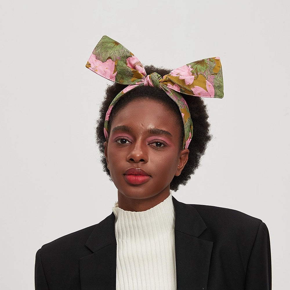 Floral printed bow headband in green, pink, and brown on women's head
