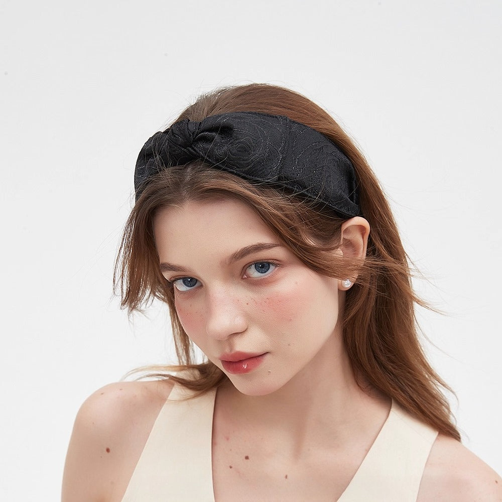 Black bow headband with subtle textured floral pattern, women's embellishment accessory