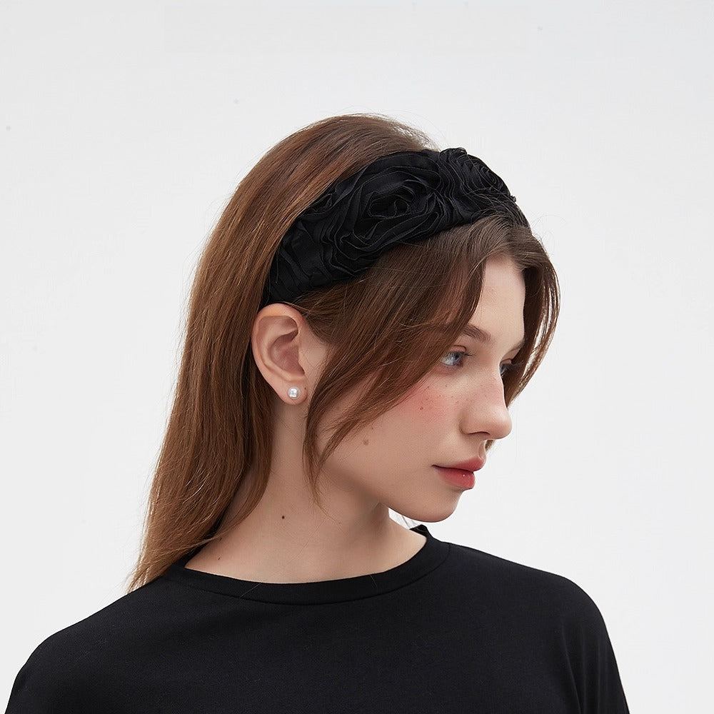 Black ruffled fabric headband with a textured floral design, minimalist women's hair accessory