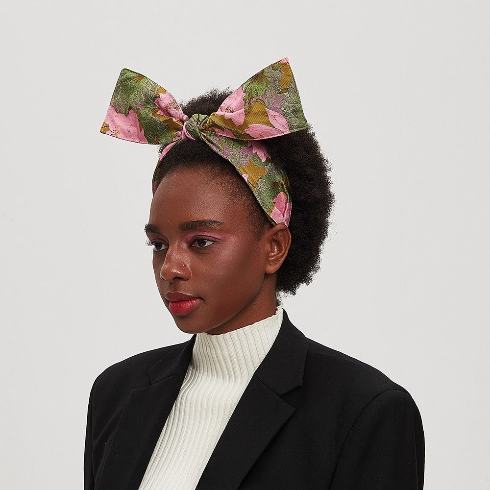 Printed bow headband with pink and green floral pattern on woman, women's fashion accessory