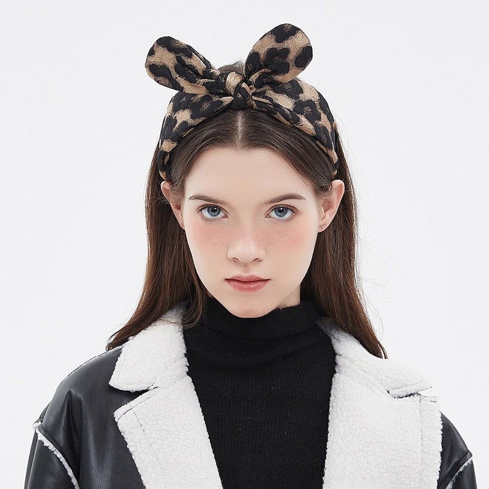 Women's leopard print bow headband in fabric with black and brown pattern