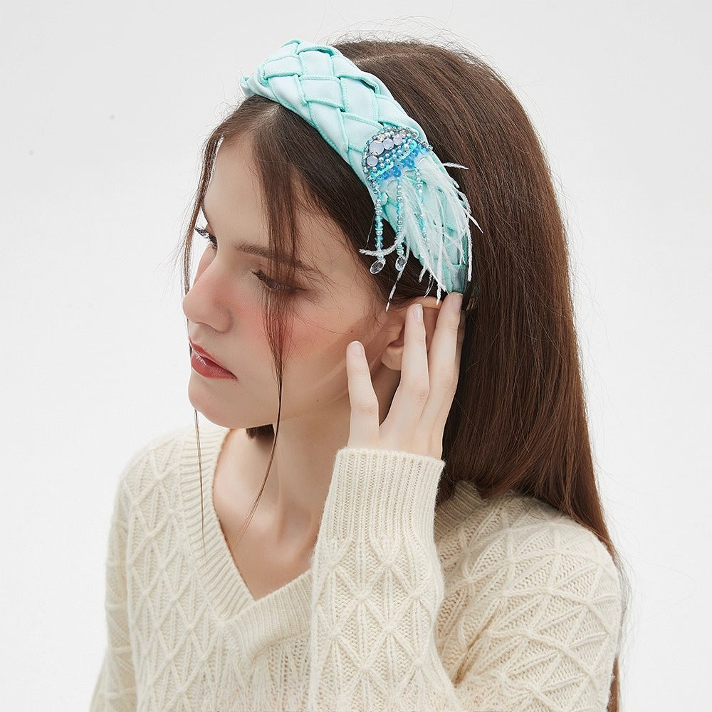 Light blue quilted fabric headband with embellished bead and feather details