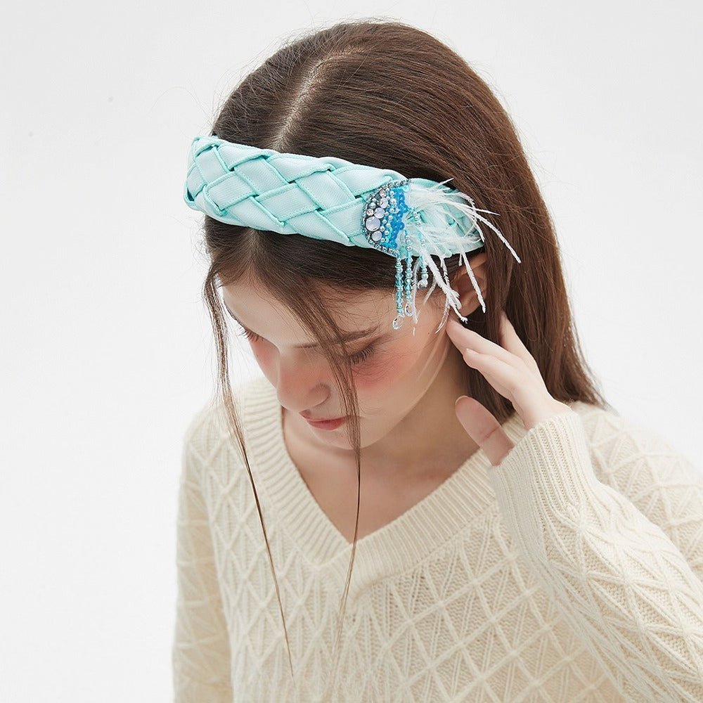 Light blue embellished women's headband with quilted satin fabric, rhinestones, beads, and feathers